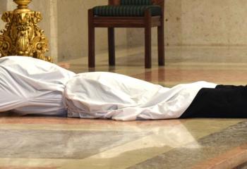 Deacon John Hutta prostrates himself before the altar as a sign of submission before God and total reliance on his grace during the Litany of Supplication (Litany of the Saints). (Photo by John Simitz)