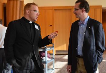 Father Mark Searles, chaplain of Allentown Central Catholic High School (ACCHS) and member of the board, chats with James MacDougall, vice chair of the board.