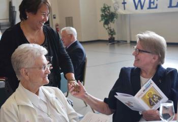 MarySue Rother greets Missionary Sisters of the Most Sacred Heart of Jesus (MSC) from Reading, Sister Mary Seibert, left, and Sister Bernard. (Photo by John Simitz)