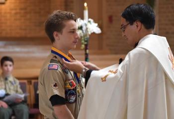 Father Eric Tolentino presents Christopher Dunlap with the Ad Altare Dei Award. (Photo by John Simitz)