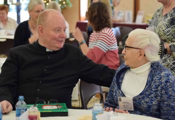 Father Brensinger talks with Rose Tucci, parishioner of Holy Rosary, Reading. (Photo by John Simitz)