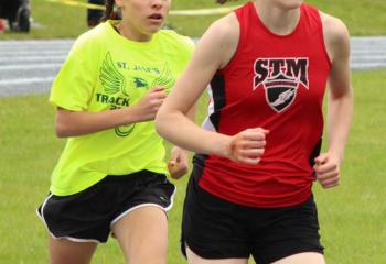 Sydney Azzalini, left, St. Jane and Isabel DeVos, St. Thomas More, race at the track and field meet. Twenty diocesan teams competed in the meet with St. Jane finishing third with a score of 108.