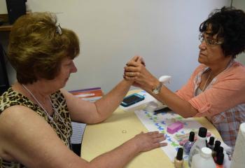 Mary Lou Yanushefsty, right, prepares Julie Merenda’s hands for a manicure. (Photo by John Simitz)