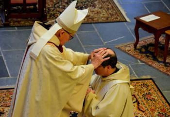 Benedictine Abbot Cletus Meagher, Father Linus Klucsarits’ abbot, imposes his hands on the new priest’s head during the ordination. (Photo courtesy of Father Linus Klucsarits)