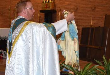 Father Mark Searles crowns the Blessed Mother after the procession. (Photo by John Simitz)
