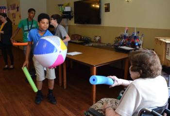 Holy Family Manor resident Mary Vidonya and a Quo Vadis camper play Noodle Ball. (Photo by John Simitz)