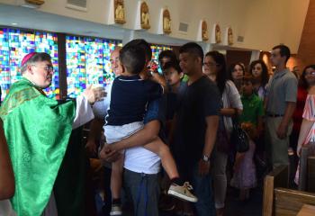 Bishop-elect Schlert greets families after the opening Mass. (Photo by John Simitz)
