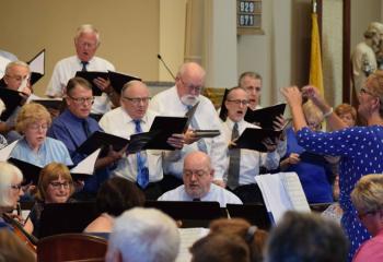 Beverly McDevitt, right, director of the Cathedral and Diocesan choirs, leads the cathedral’s adult choirs – Angelorum Choir, Cathedral Choir, Diocesan Choir and Living Word Choir – in singing the “Magnificat.” The piece is taken from the Gospel of Luke and is the Blessed Mother’s hymn of praise to the Lord. 