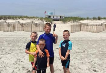 Msgr. O’Connor joins, from left, Maxwell, Hudson, Quincy and Wyatt Clews on their vacation to Stone Harbor, New Jersey.