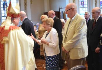 Bishop Schlert congratulates Robert and Mary Ann Sterner at the celebration recognizing their 60th wedding anniversary.