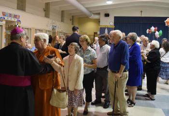 Bishop Alfred Schlert greets faithful from the Berks Deanery during the reception after the Mass. 