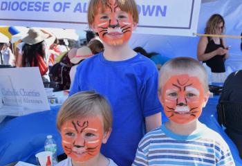 Smiling after face painting at the Catholic Charities, Diocese of Allentown booth are, from left, Jacques, Thomas and Peter. (Photo by John Simitz)