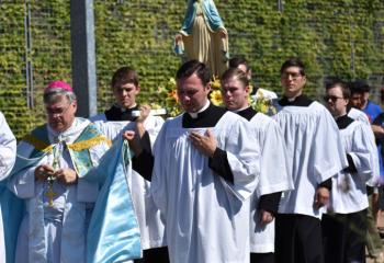 Bishop Alfred Schlert participates in the rosary procession as seminarians carry an image of Our Lady of Fatima. (Photo by John Simitz)