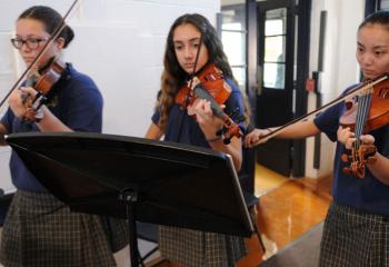 Music Ministry violinists are, from left, Annlisse Lynch, Sahah Atileh and Cathy Young. (Photo by Ed Koskey)