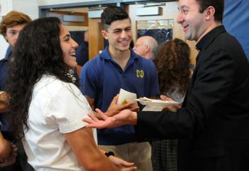 Father Stephan Isaac, a 2006 graduate of Notre Dame, talks with students Jennie Melhem and Arthur Jacob after Mass. (Photo by Ed Koskey)