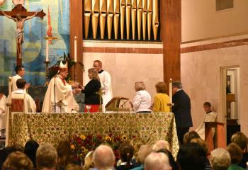Bishop Alfred Schlert receives the gifts.