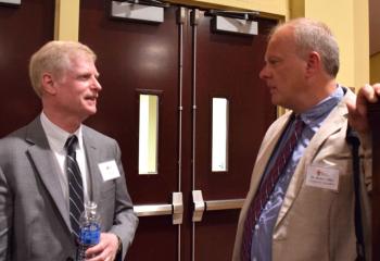 John Bakey, left, Diocesan chancellor for Catholic education, and speaker Brian Collier chat during the convention.