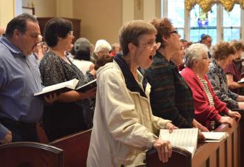 Faithful sing a Marian hymn during the Mass.