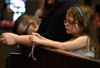 Blakesly Moser prays the rosary during Eucharistic adoration at St. Elizabeth. (Photo by John Simitz)