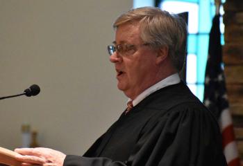 Judge Thomas Parisi serves as lector for the first reading.