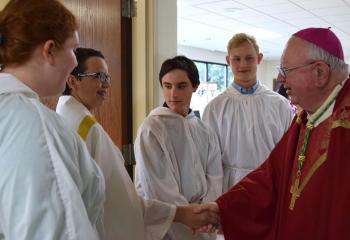 Bishop Murphy greets altar servers, from left, Danielle Dougherty, Kevin Zambito, Daniel Gombar and Reese Griffin.
