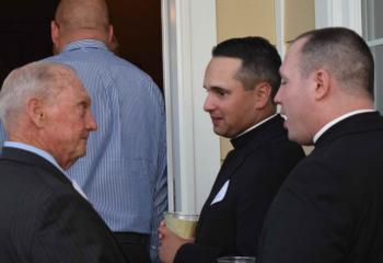 Michael Ehlerman, left, talks with Father Keith Mathur and Father Christopher Butera.