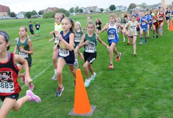 Third- and fourth-grade girls run close together during the meet.