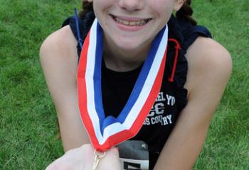 Veronica Gaulai of St. Michael the Archangel School, Bethlehem-Limeport shows the medal she earned for placing first in the fifth- and sixth-grade girls’ race.
