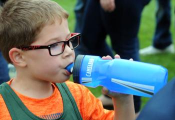 Lincoln Feist of St. Jane drinks from his water bottle after running with kindergarten boys.