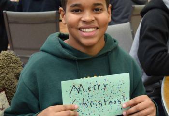 Julius Baker shows off a Christmas card he created for a prisoner. (Photo by John Simitz)
