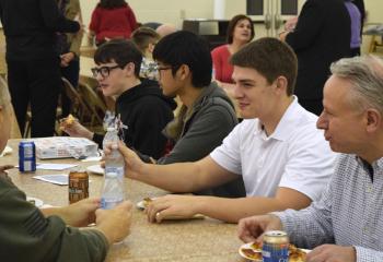 John Maria, right, and Keaton Eidle, second from right, diocesan seminarians, talk with young men about their experience at “Quo Vadis.”
