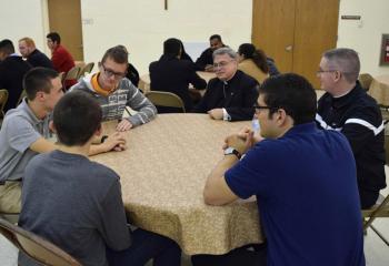 Bishop of Allentown Alfred Schlert, center, listens to young men reflect on their experience at “Quo Vadis.” Also seated at the table are, clockwise from right: Father Kevin Lonergan, seminarian Giuseppe Esposito, Keith Neidig, Ben Scheaffer and Gerard Behe.