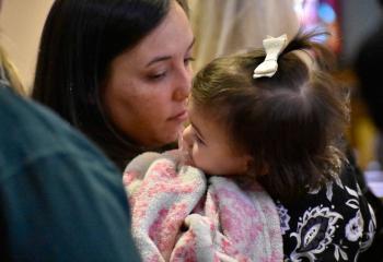 Jessie Gill holds her 1-year-old daughter Hanna during the morning liturgy. (Photo by John Simitz)