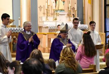 Emily Yuschock presents the offertory gifts to Bishop Alfred Schlert. (Photo by John Simitz)