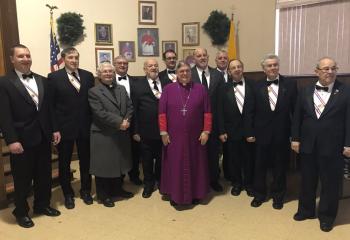 Bishop Alfred Schlert, center, gathers in the parish hall after Mass with Father Paul Rothermel and members of the Knights of Columbus. (Photo courtesy of Marie Breininger)