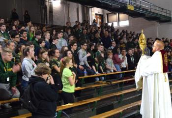 Father Searles raises the monstrance during benediction.