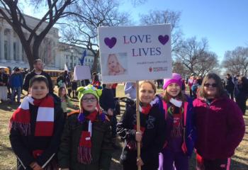 The youngest members of the Schuylkill County group, all returning marchers, proudly display the banner leading the group, from left, Chris Dembinsky, Jake Smalley, Dalton Seisler, Callie Seisler and Katie Smalley. (Photo courtesy of Heather Smalley)