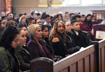 Catechumens listen to the homily during the ceremony that called them to the sacraments at Easter.