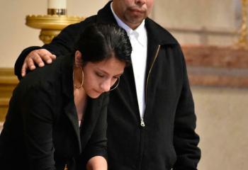 Jacqueline Valencia enters her name into the Book of the Elect with support from Miguel Lemus, parishioner of St. Paul, Reading.