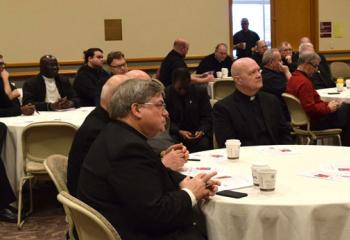 Bishop Alfred Schlert, left, and priests listen to Bishop William Waltersheid’s morning presentation.