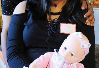 Osbel Polanco Calderon, left, and Nashaly Cruz Pagon, whose daughter Nashbel was born Jan. 10, hold a doll at the shower. (Photo by Ed Koskey)