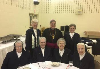 Bishop Alfred Schlert with members of the Sisters, Servants of the Immaculate Heart of Mary at the dinner, from left: front, Sister Miriam Dennis Sculley, Sister Teresa Paul, Sister Marian Bernadette Chuk and Sister Marie Eugene Reed; back, Sister Anita Gallagher, Bishop Schlert and Sister Lorraine Holzman.