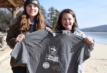 Hannah McGinley, left, and Megan Reaman, sixth grade students at St. Joseph Regional Academy, Jim Thorpe, sell T-shirts commemorating the Polar Plunge and to raise funds for their school. (Photo by John Simitz)