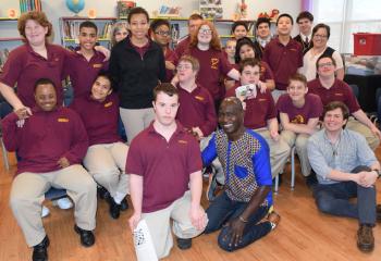 Thomas Awiapo, front center, and Jeff Wallace, front right, CRS relationship manager with the Diocese of Allentown, spend time with students and staff at Mercy School for Special Learning as they become the first school for special learning to contribute to the mission of CRS. (Photo by John Simitz)