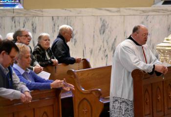 Gus and Shirley Heidecker, front left, join other Serrans praying as Monsignor David James leads the Rosary for Vocations.