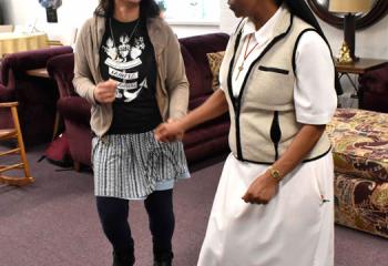 Missionary Sister of the Precious Blood Anastasia Mallya, right, does a little dance with Estefania Perdomo.
