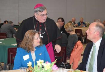 Bishop Schlert chats with Lisa Siciliano and Hal Messer, parishioners of St. Catharine of Siena, during the kickoff.