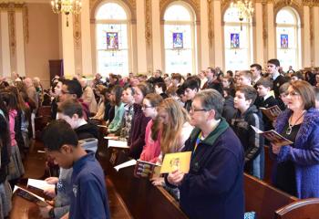 Faithful and students from Diocesan schools pray together at the Chrism Mass, solidifying the bond of unity among the Bishop, priests, the sacraments and the people who receive them.