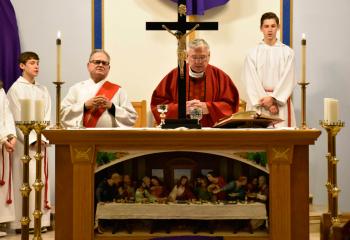 Father Joseph Whalen, pastor of St. Richard, Barnesville, center, and Deacon John Setlock, left, participate in the Good Friday service, March 30 with the altar cross as the focal point for meditation of Christ’s death at Calvary.