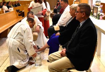 Father George washes the feet of parishioners during Holy Thursday service. The ritual recalls Jesus, the Son of God, washing the feet of his disciples, symbolizing that he came to serve others and reminds the faithful they are also called to serve others.